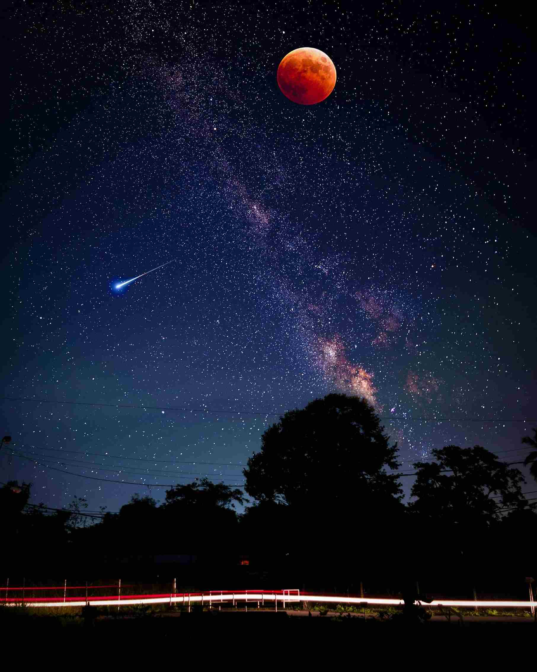  Night sky full of stars and the milky way galaxy visible with a red moon and  ashooting star down to the left of the milky way