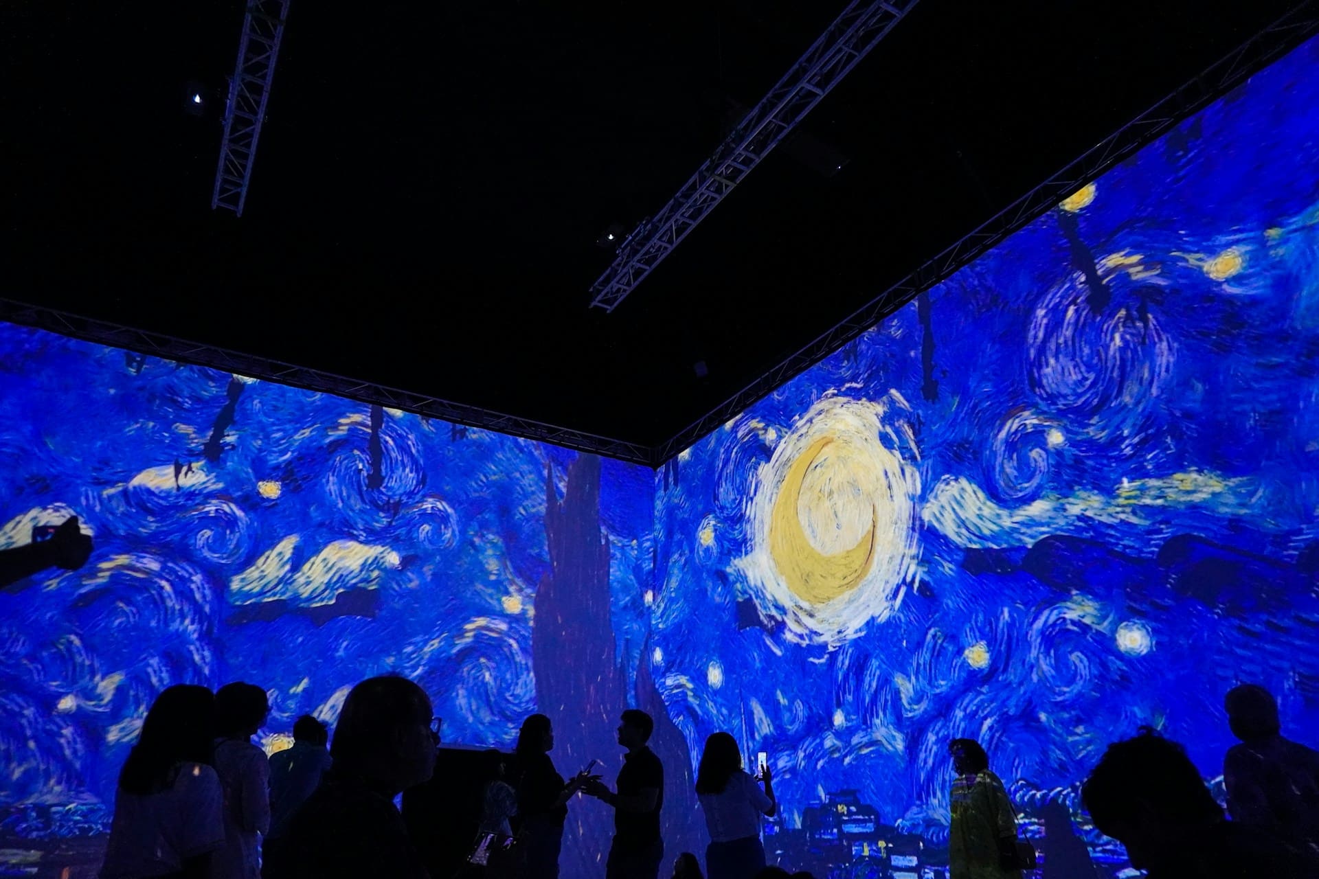 Immersive exhibit of Van Gogh’s Starry Night with visitors